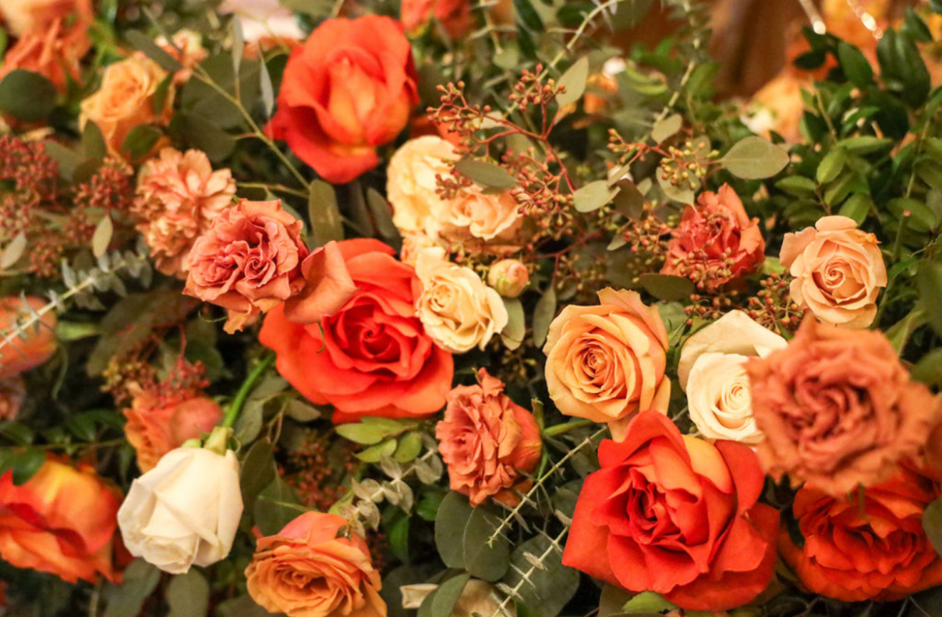 Rich coral and cream roses with eucalyptus