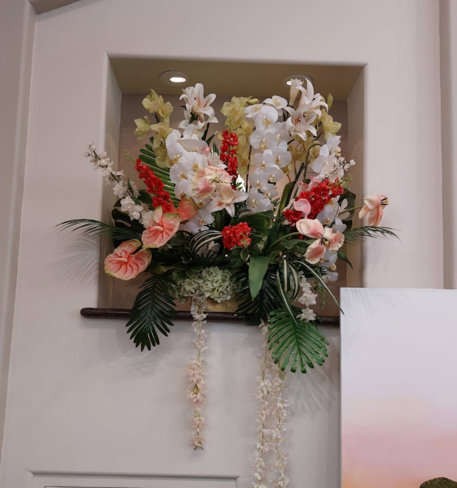 Tropical wall arrangement with white orchids and anthuriums