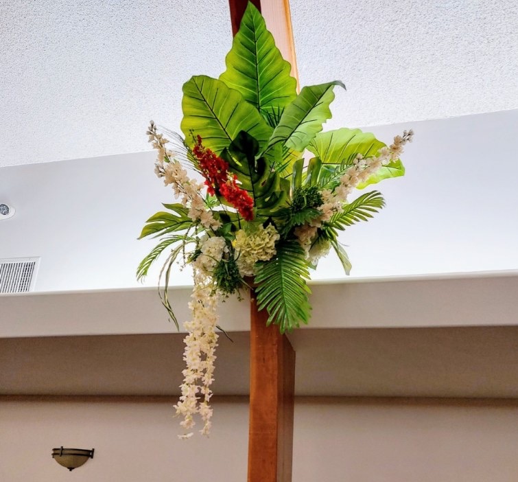 Botanical column arrangement with tropical leaves